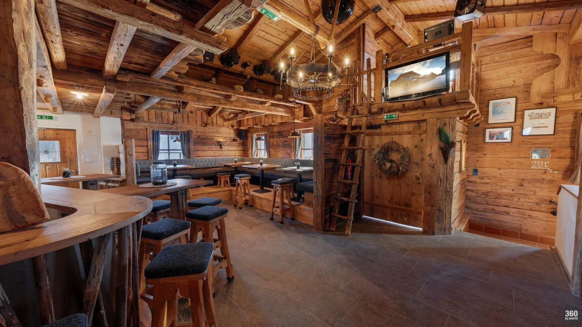 Die Trinkerei mit runder Holztheke und Barhockern